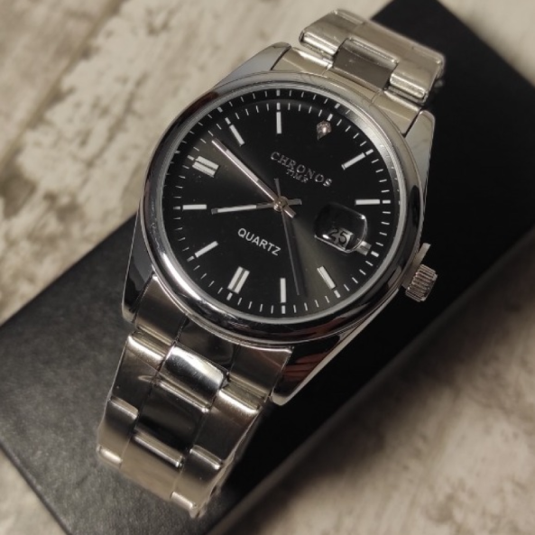 Montre-Bracelet de Luxe CHRONOS Homme Quartz. Avec un cadran noir intense un bracelet en acier inoxydable et une fenêtre de date avec loupe de type cyclops, cette montre est idéal pour ceux qui recherchent l’élégance, l’élégance, précision et le caractère