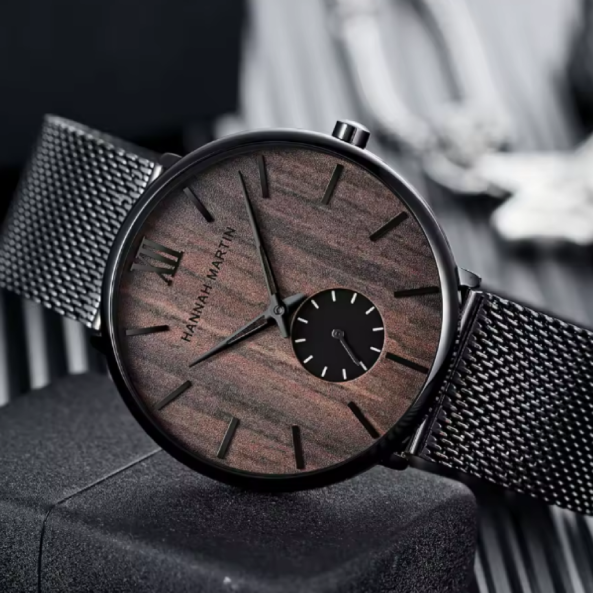 Montre-Bracelet Hannah Martin en Acier Inoxydable pour Homme. Une montre qui unit l’organisme et l’ industriel, avec un cadran effet en bois naturel, des aiguilles noires élégantes et un bracelet en maille métallique noire.