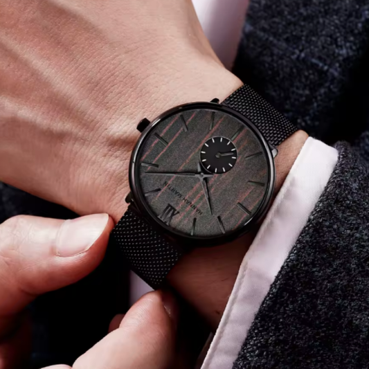Montre-Bracelet Hannah Martin en Acier Inoxydable pour Homme. Une montre qui unit l’organisme et l’ industriel, avec un cadran effet en bois naturel, des aiguilles noires élégantes et un bracelet en maille métallique noire.