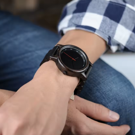 Montre BOBO BIRD en Bois d'Ébène pour Hommes et Femmes. Cette montre redéfinit l’élégance moderne avec son design entièrement noir et une aiguille rouge unique qui la distingue par son caractère, fabriqué en bois foncé.